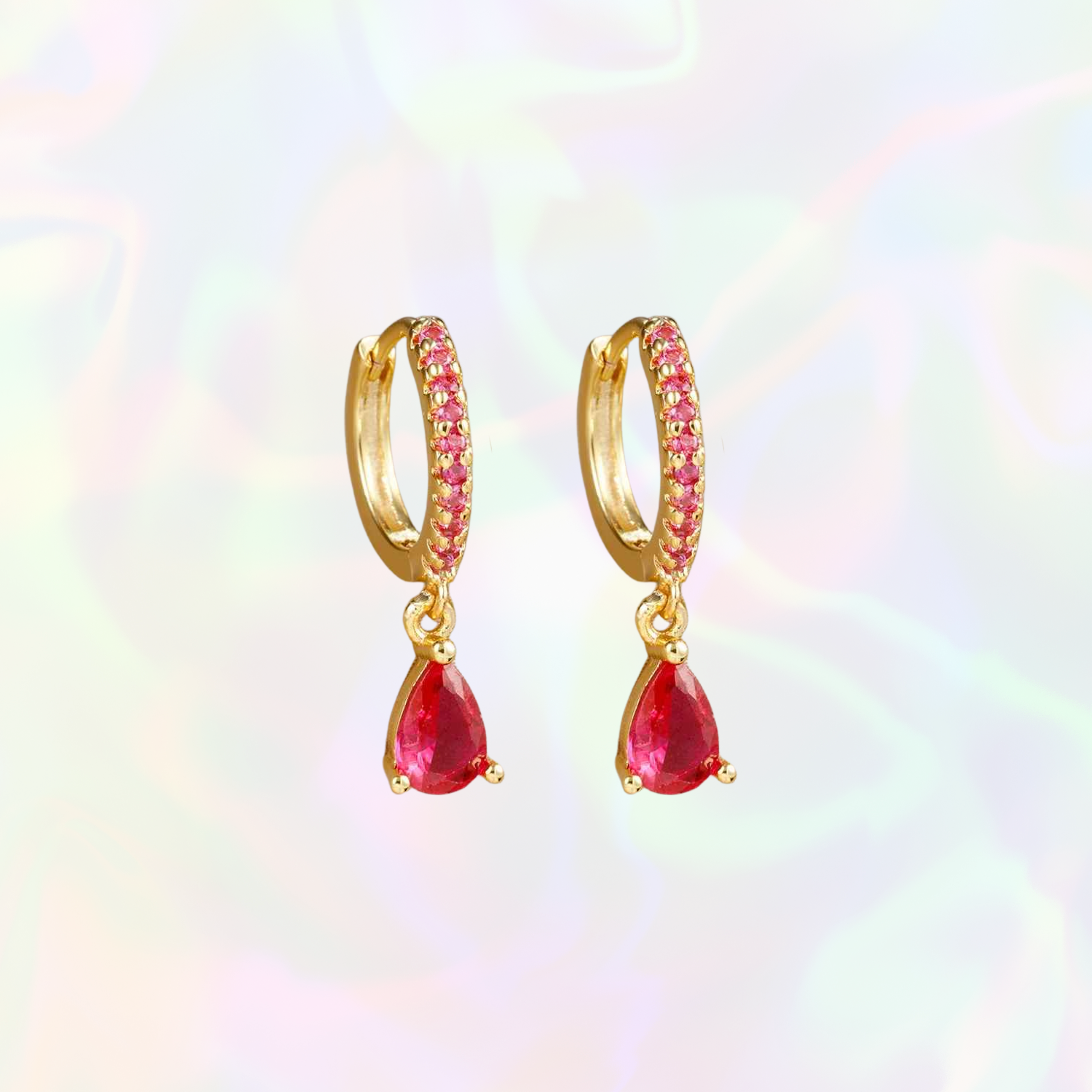 Gold hoop earrings with dark pink gemstones on a colorful background