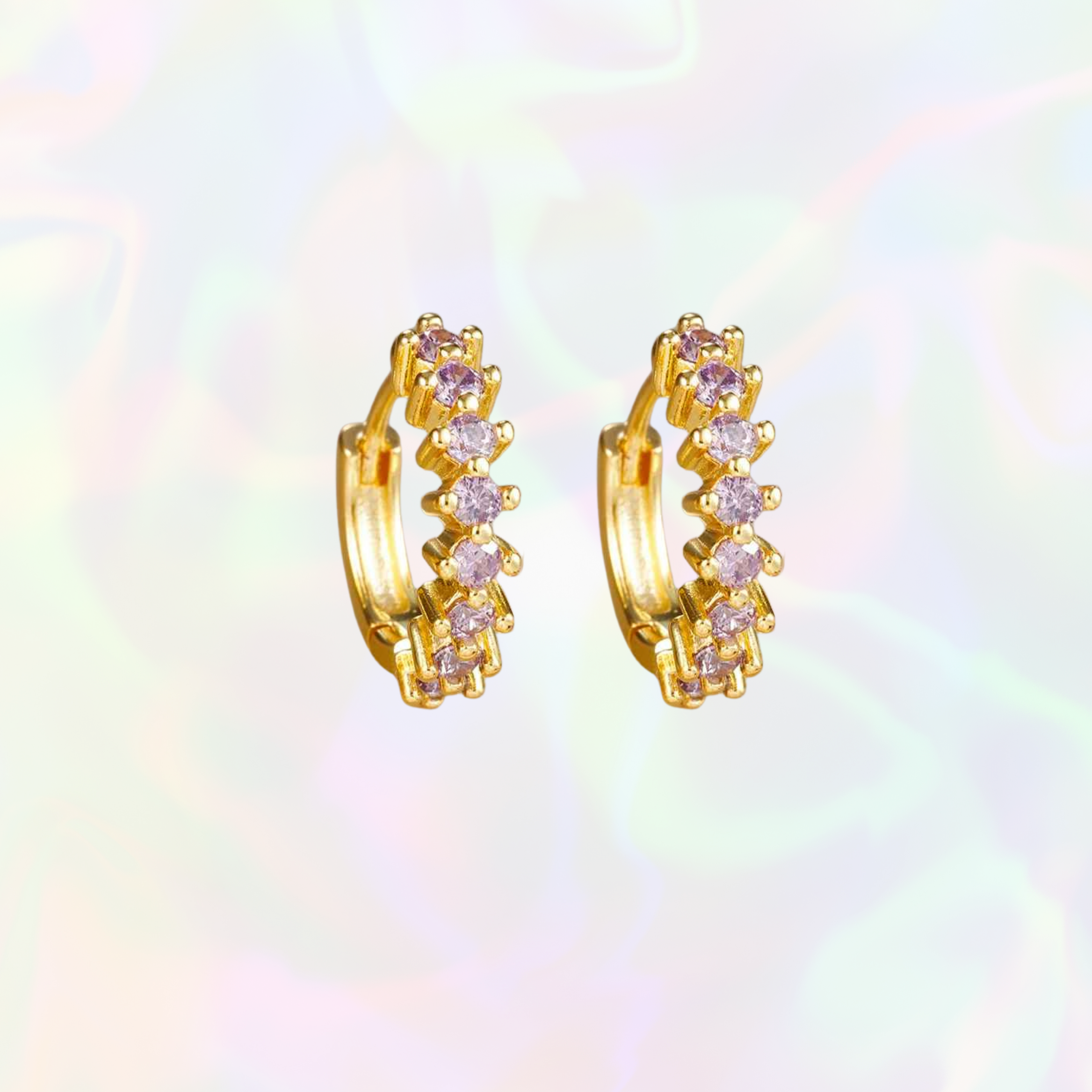 Gold sparkly hoop earrings with purple gemstones on a multicolored background