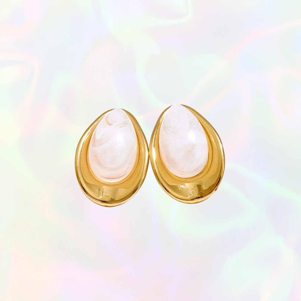 Gold waterproof earrings with white pearly stones on a multicolored background
