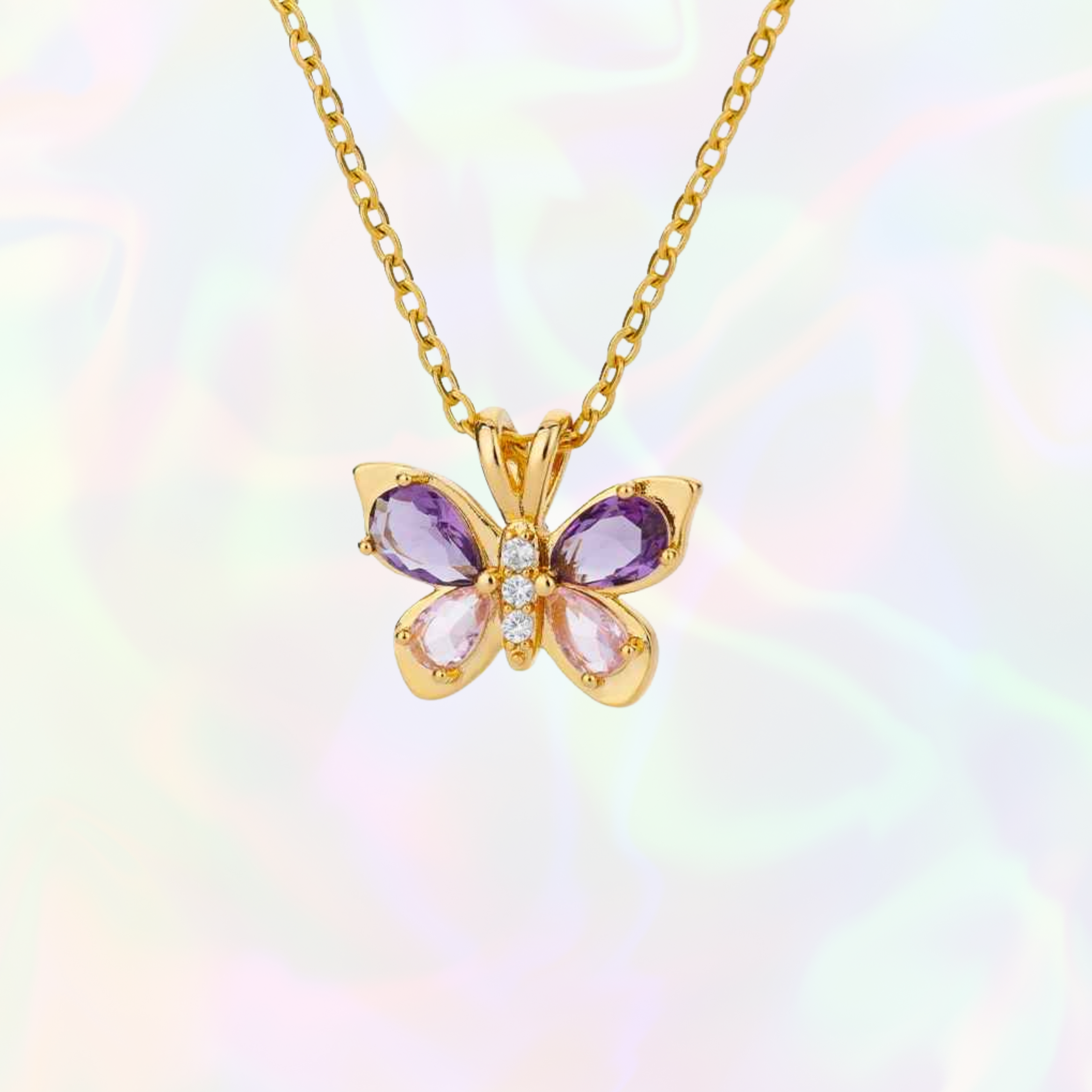Butterfly-shaped pendant with gemstones on a gold chain against a multicolored background
