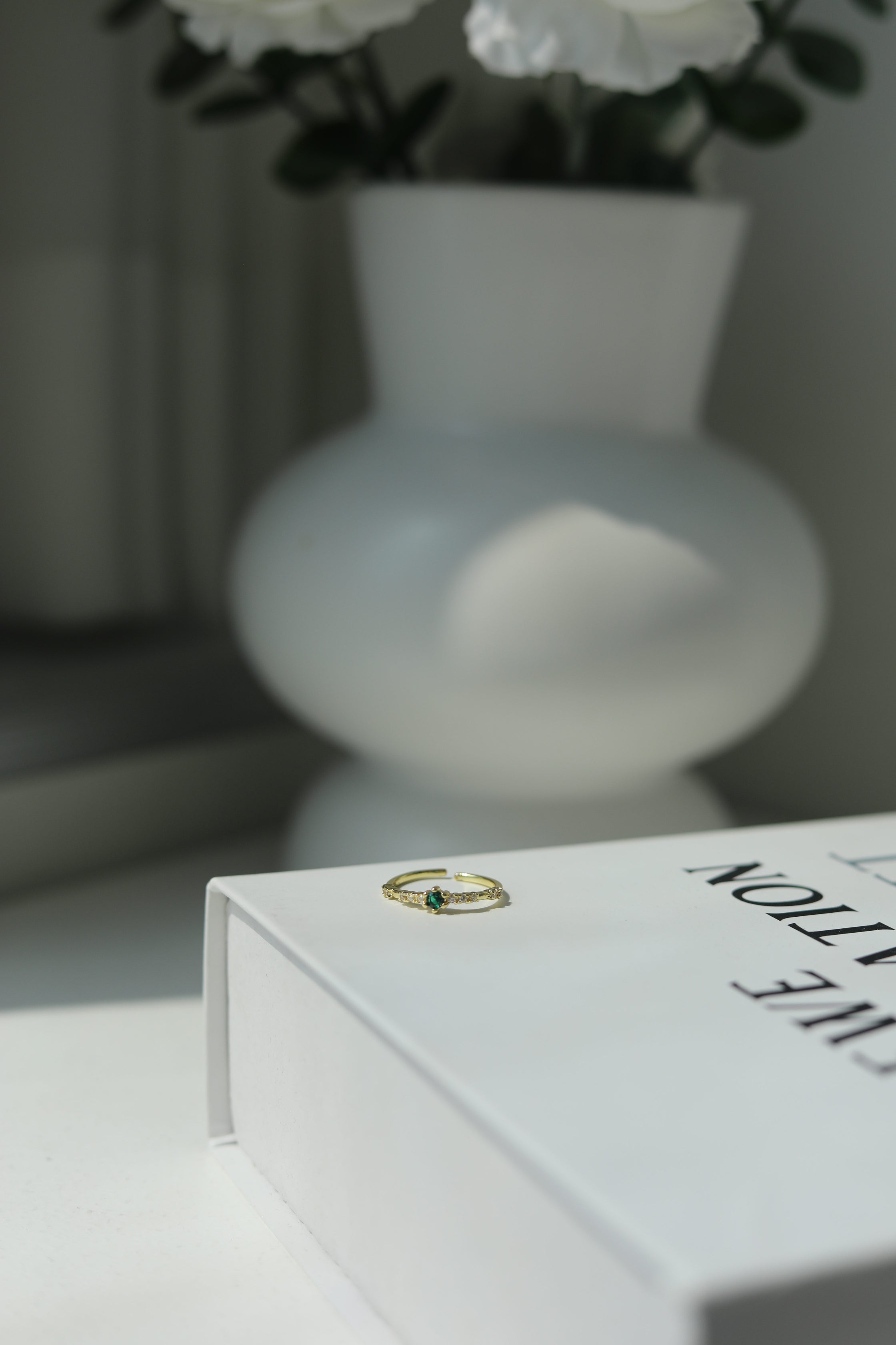 Close-up of a book with a blurred vase and flowers in the background