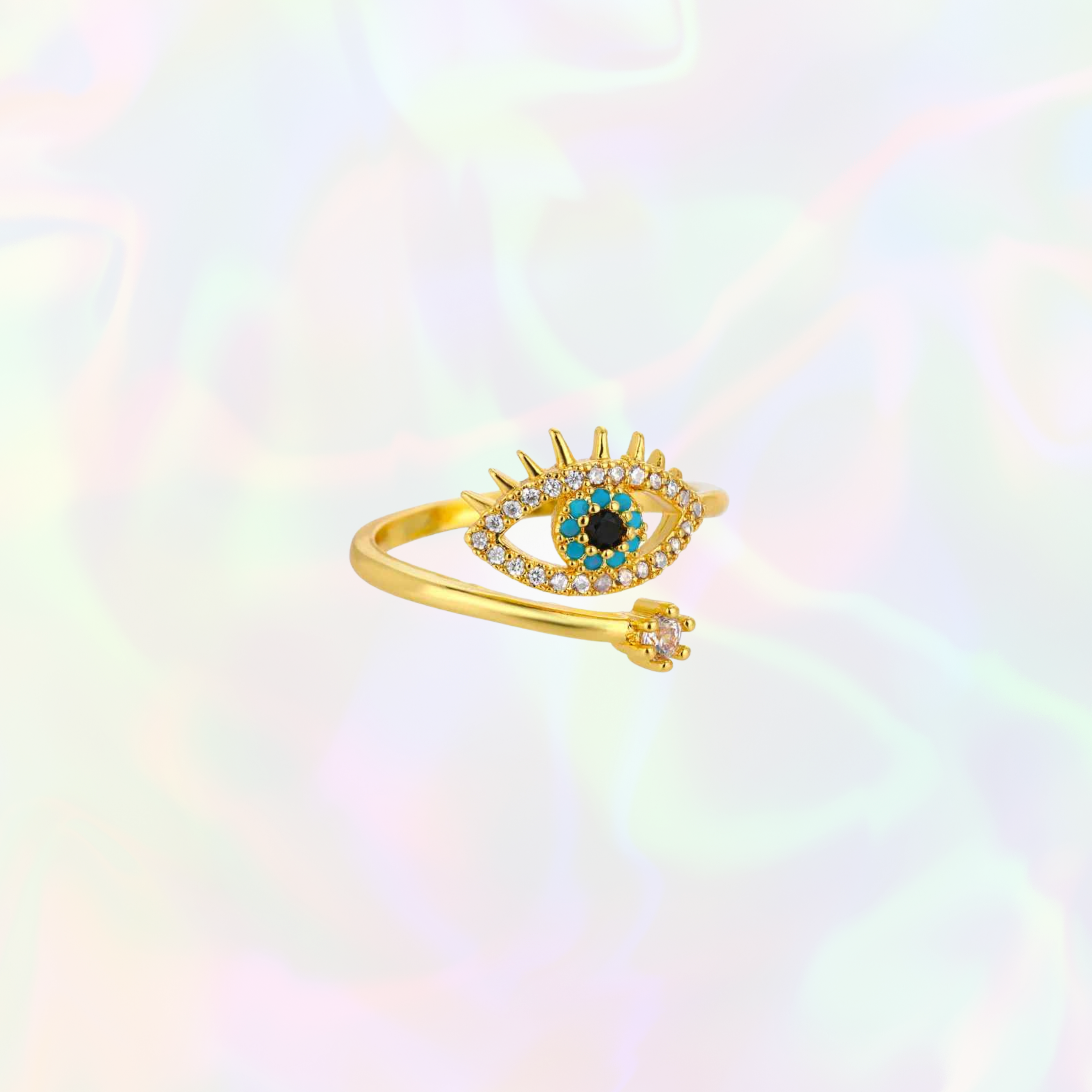 Gold evil eye ring with gemstones on a multicolored background