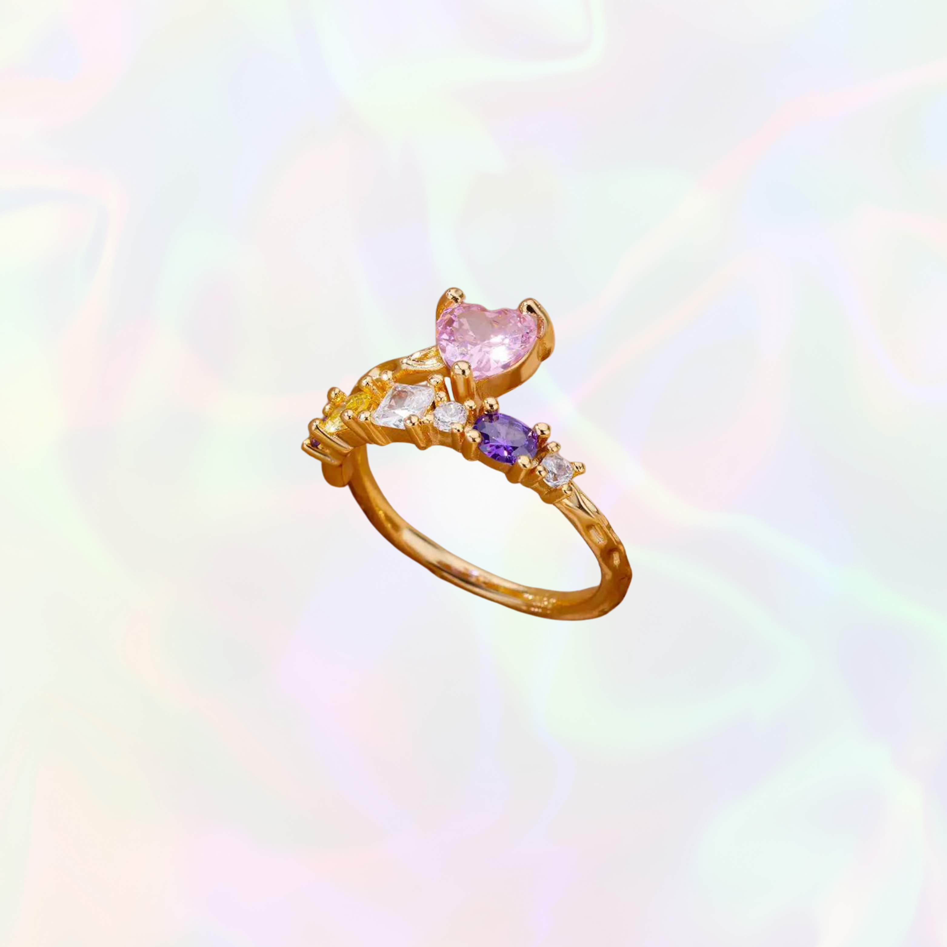 Gold ring with heart-shaped pink gemstone on a rainbow gradient background
