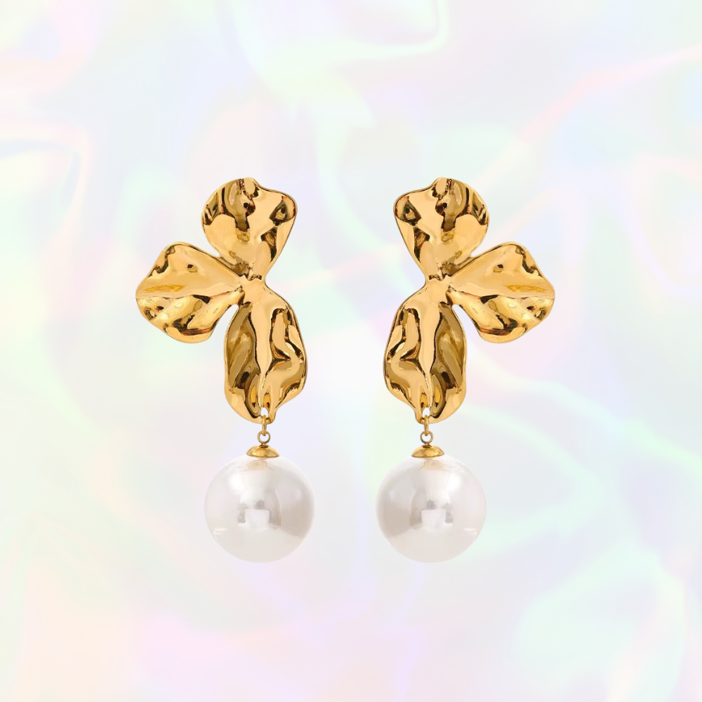 Gold earrings with pearl drops on a colorful background