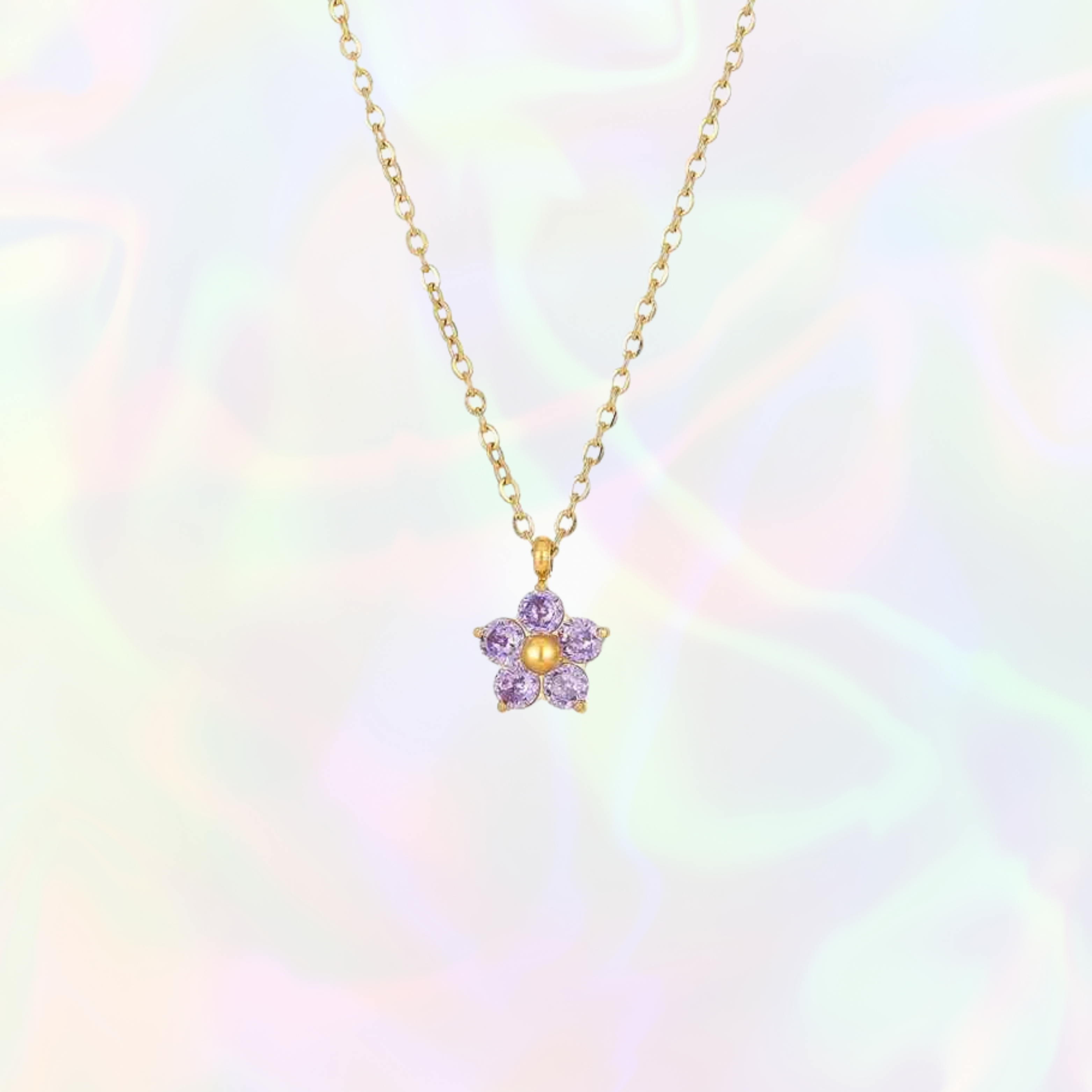 Gold necklace with a purple flower pendant on a soft, multicolored background