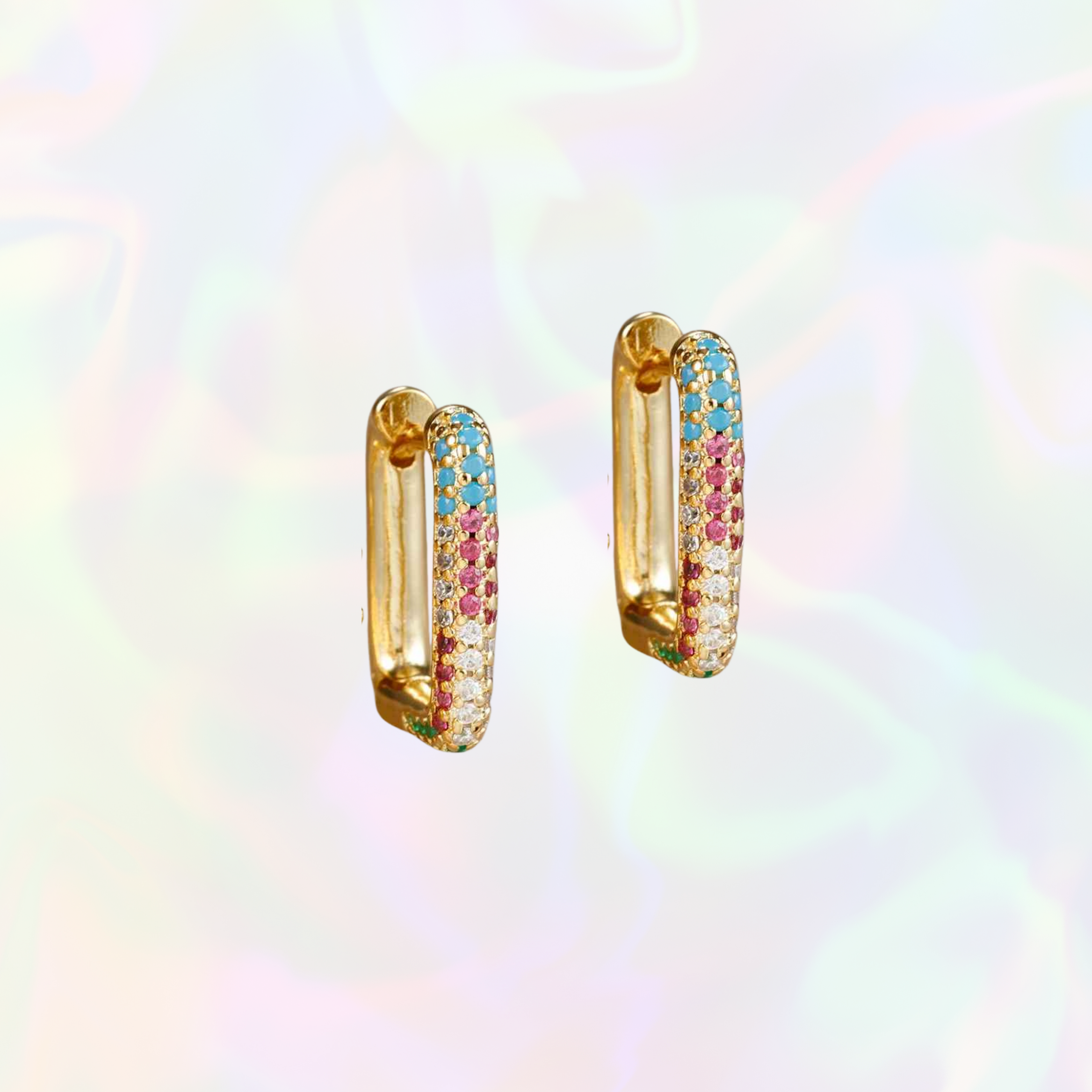 Gold hoop earrings with colorful gemstones on a rainbow gradient background