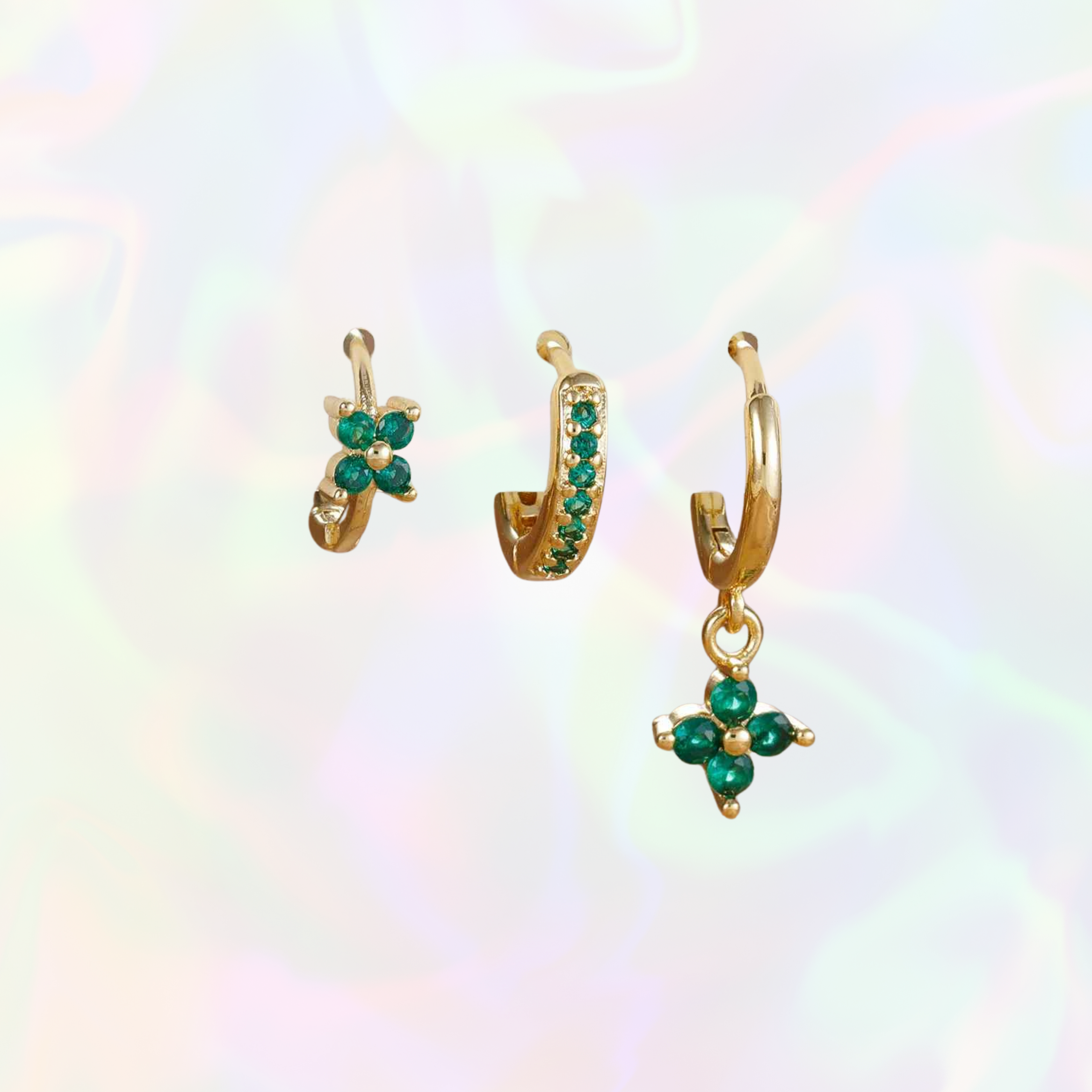 Gold earrings with green gemstones on a colorful background