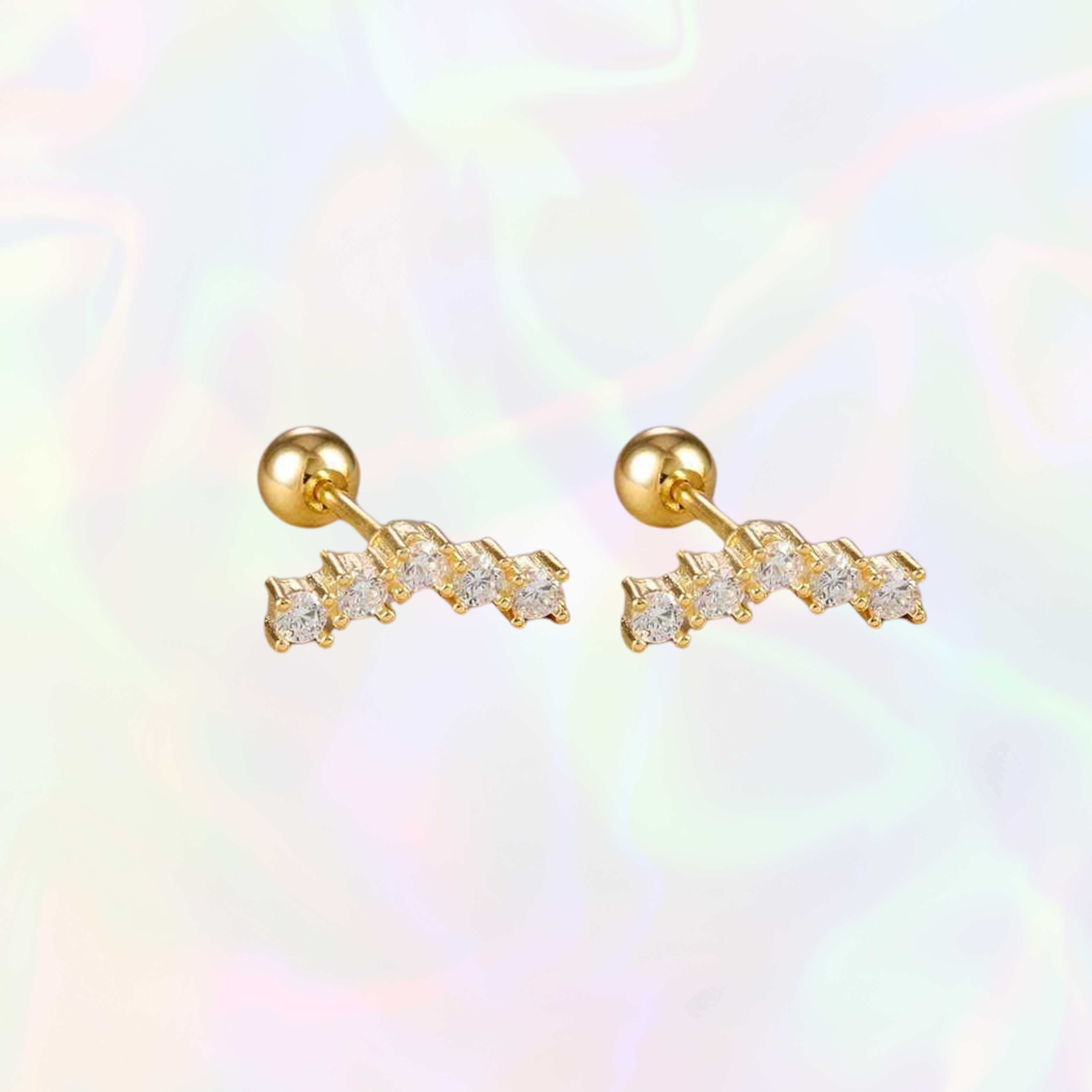 Gold long stud earrings with clear stones on a multicolored background