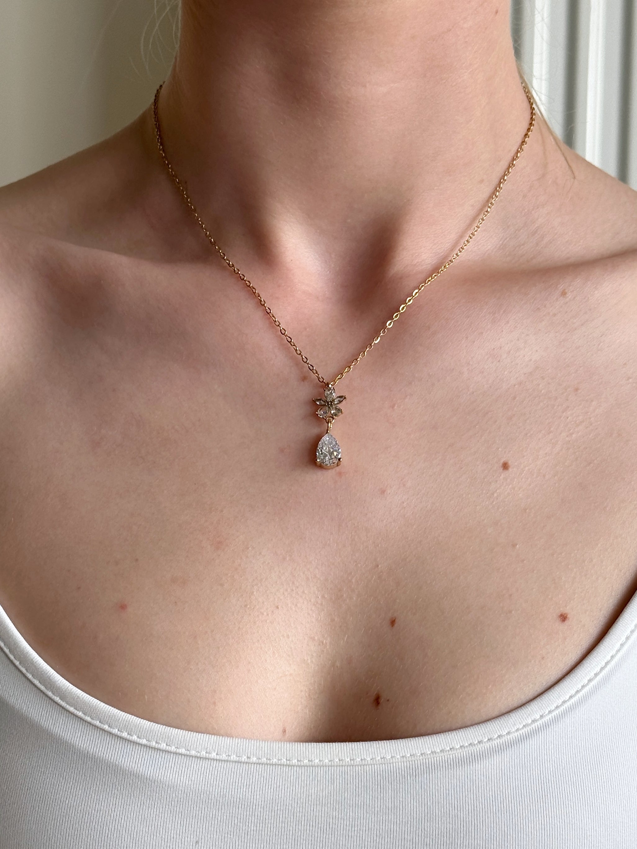 Necklace with a pendant worn by a person, close-up shot.