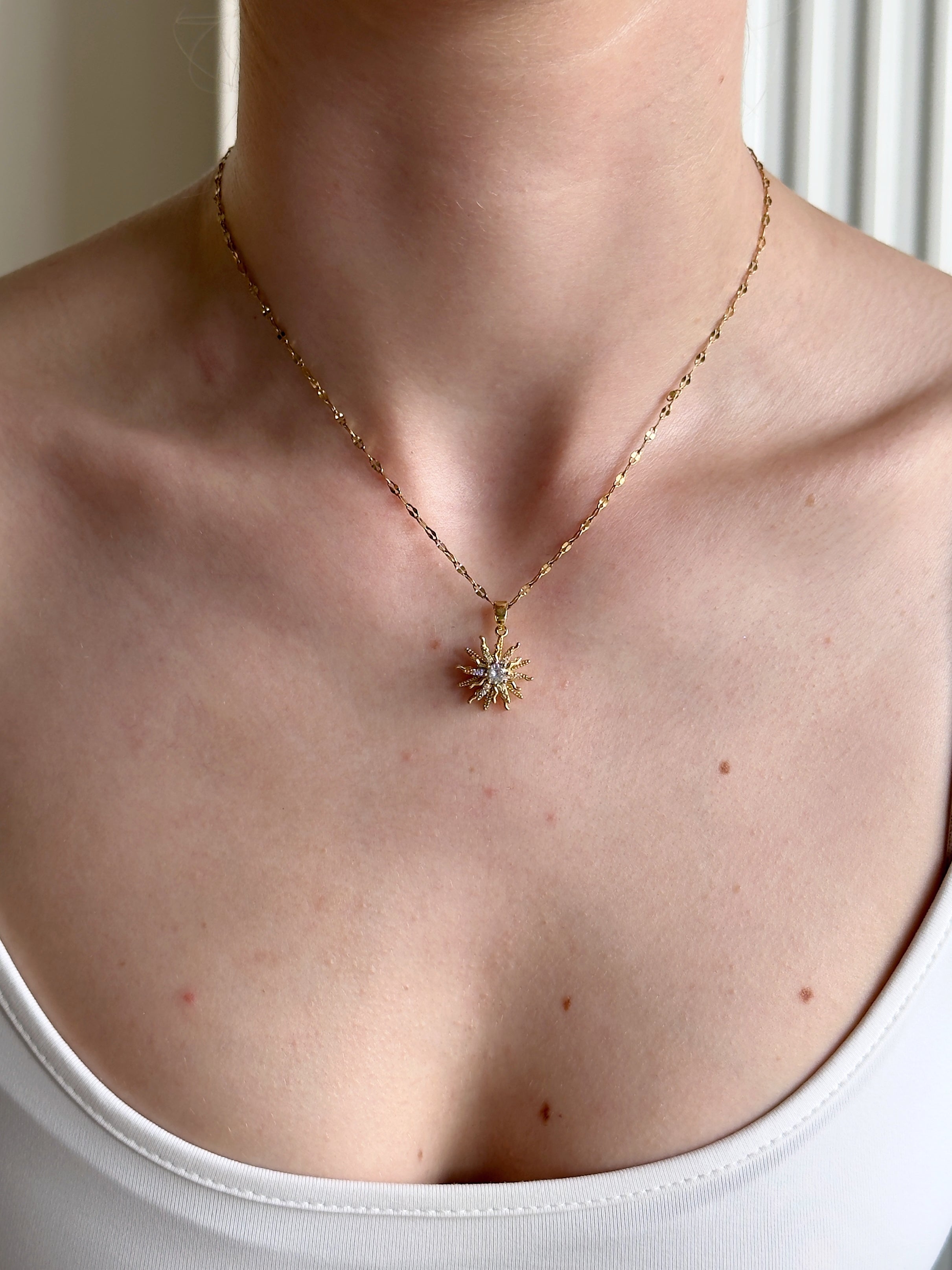 G necklace with a star-shaped pendant worn by a woman