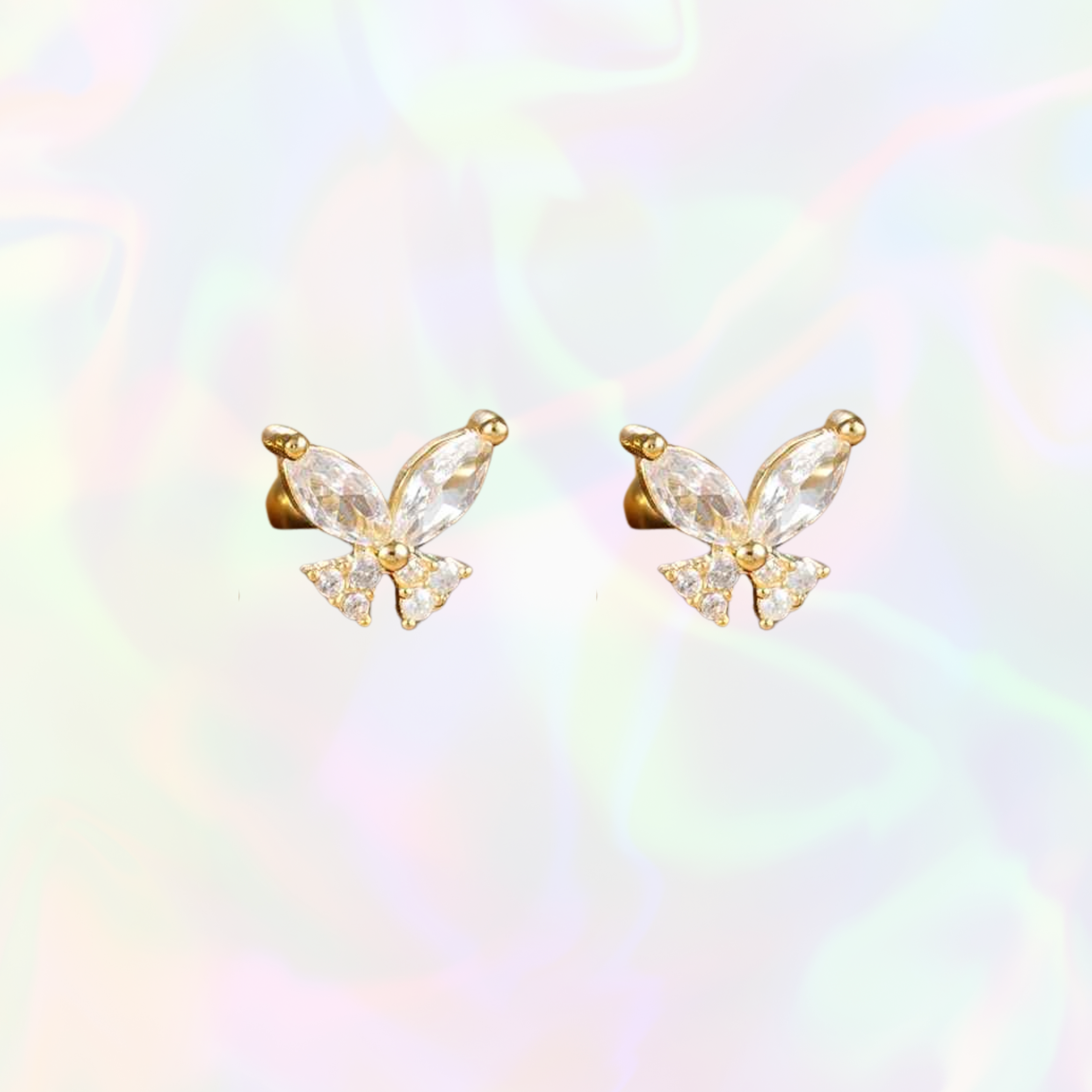 Dainty butterfly-shaped stud earrings with gold and clear gemstones on a rainbow gradient background