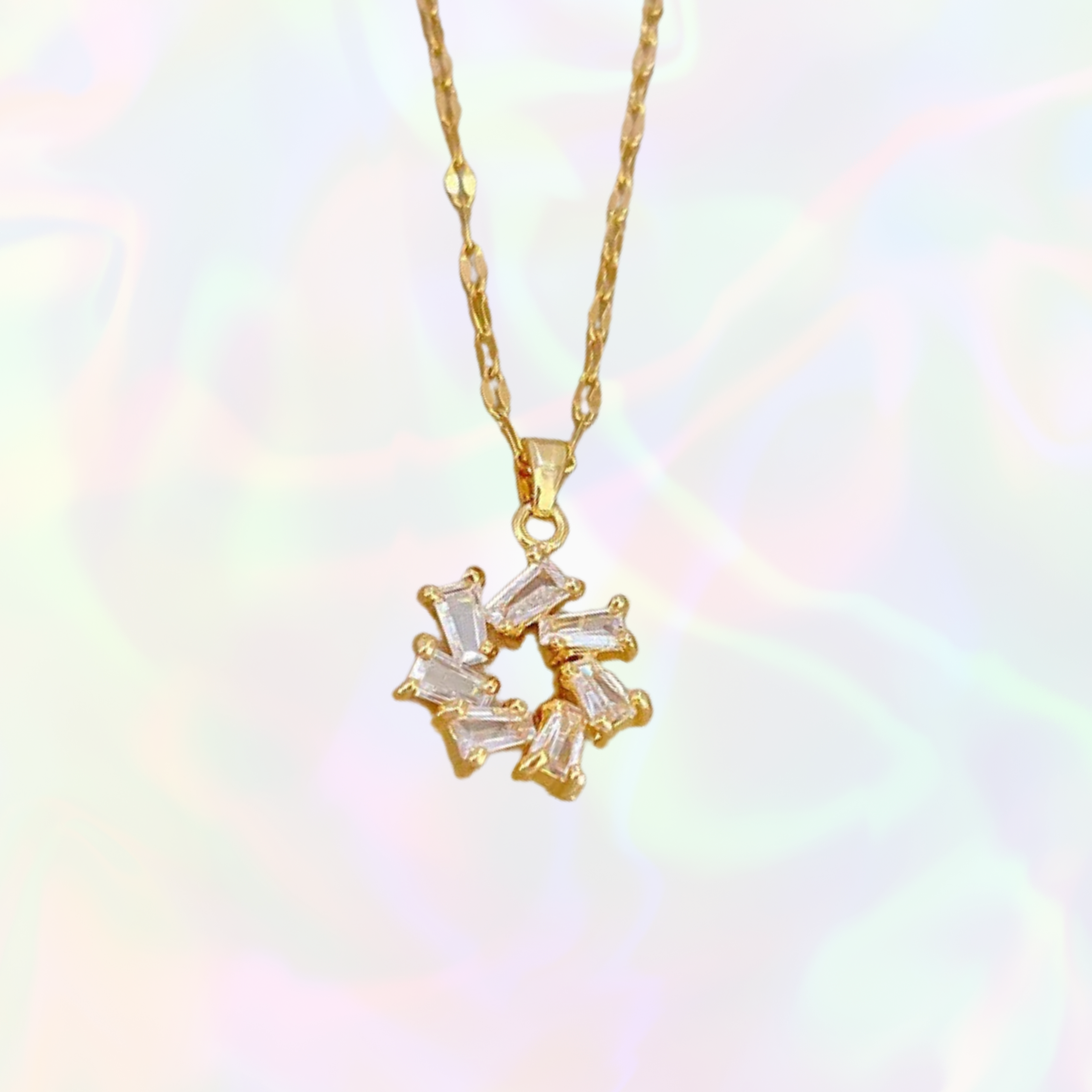 Gold necklace with a diamond pendant on a soft, multicolored background